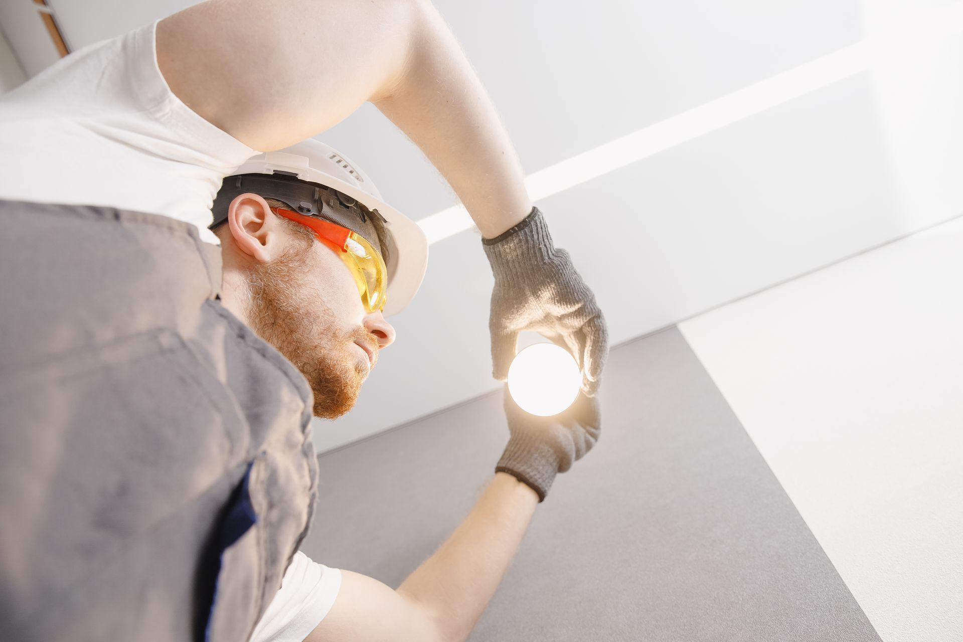 Installation d'éclairage chez un particulier Electricien Assemtech changeant une ampoule électrique chez un particulier